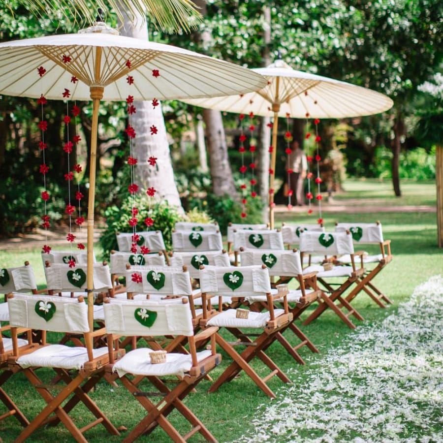 Outdoor ceremony seating at tropical wedding with parasols