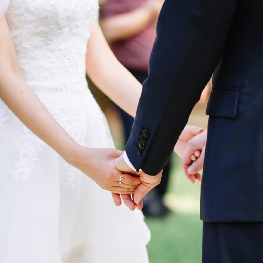 Bride and groom holding hands during wedding ceremony