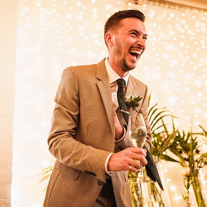 Groom laughs at wedding speeches