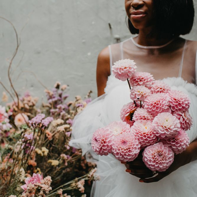 Bride holding a pink pompom wedding bouquet