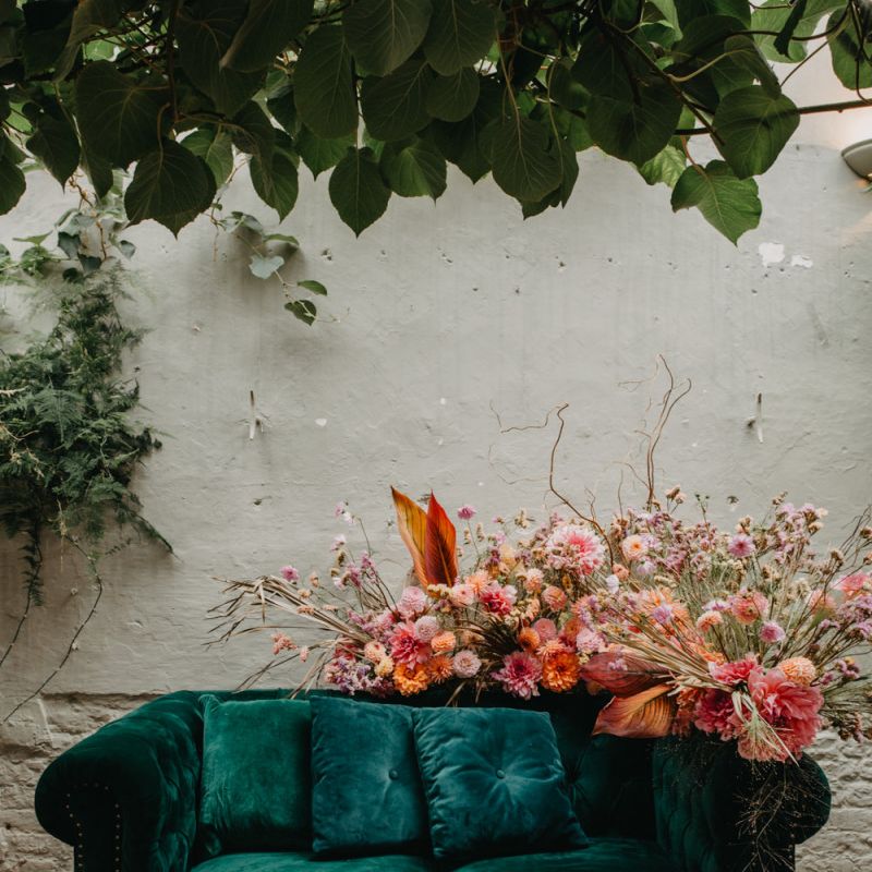 Green velvet sofa and pink wedding flowers at Secret Garden Kent