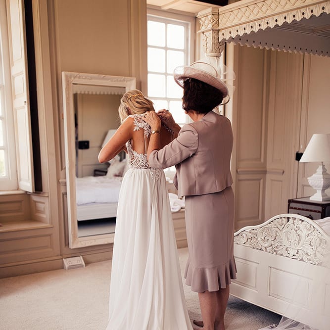 Bride on wedding morning putting on her Julio Vino wedding dress