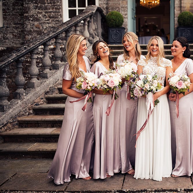 Bridal party portrait with bridesmaids in pink dresses and bride in a Julio Vino wedding dress for wedding with outdoor first dance
