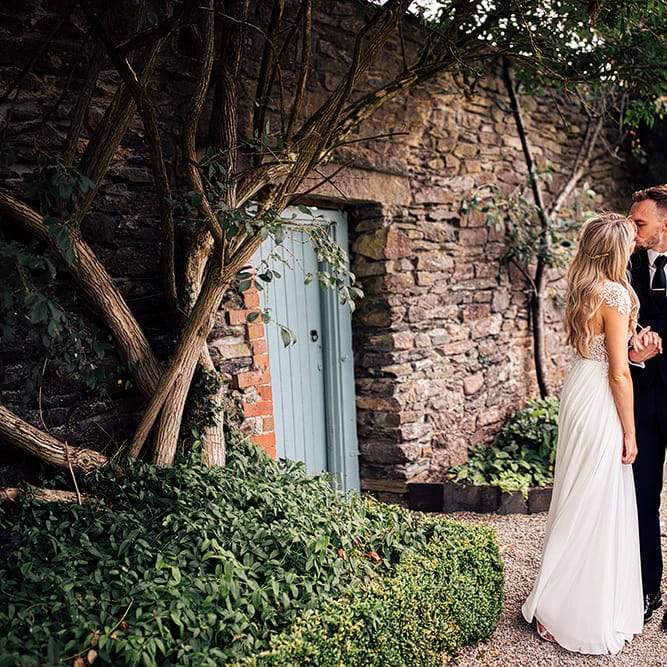 Bride and groom kissing in the gardens at Kingston Estate in Devon