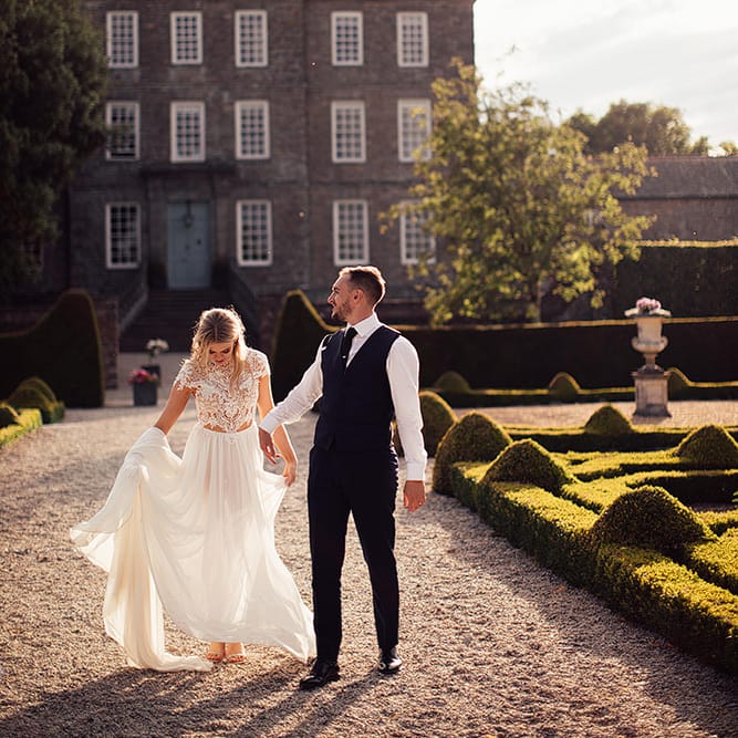 Portrait of bride in a Julio Vino wedding dress and groom in waistcoat for for wedding with outdoor first dance