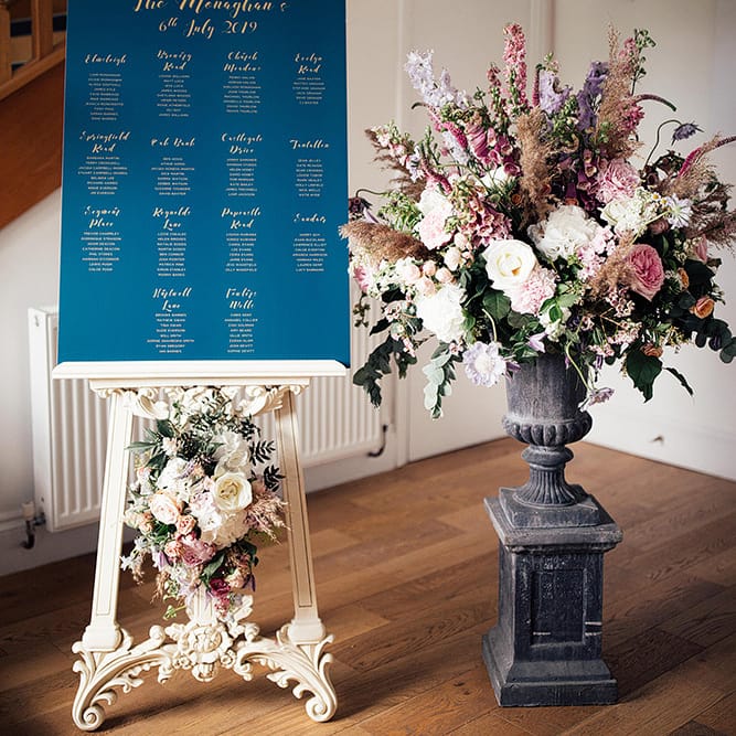 Seating chart on an easel and blush pink floral arrangement
