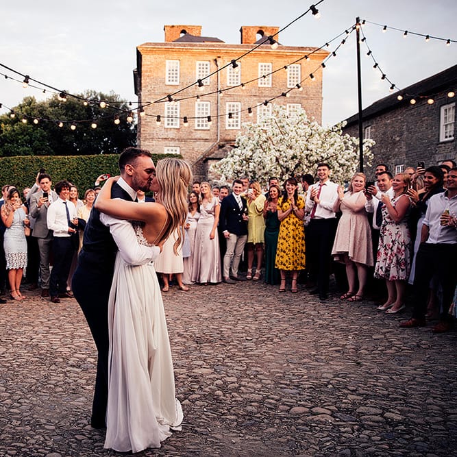 Outdoor wedding first dance under festoon lights