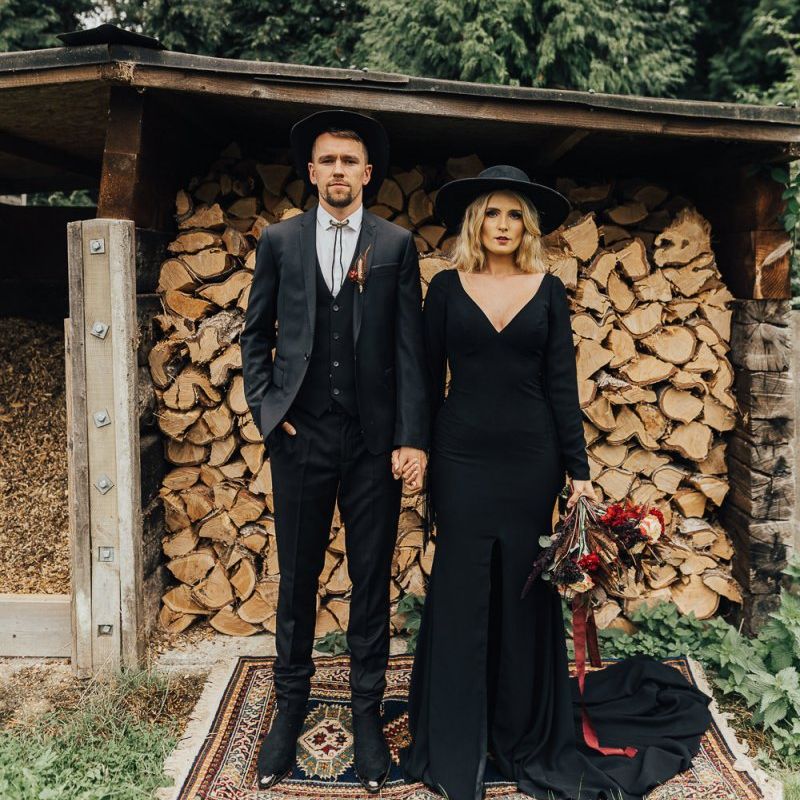 Bride and groom in a black dress and suit with hats