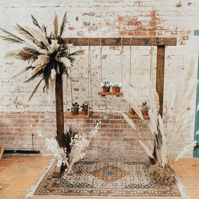 Hanging cake display with patterned rug and dried grasses at western wedding inspiration shoot