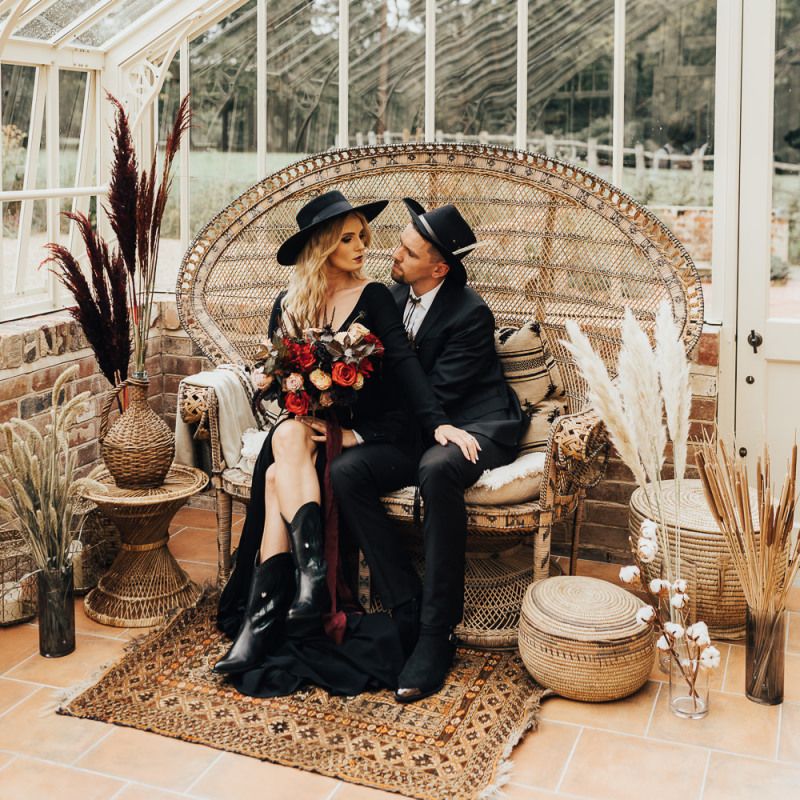 western wedding inspiration with a Bride and groom sitting on a peacock love seat