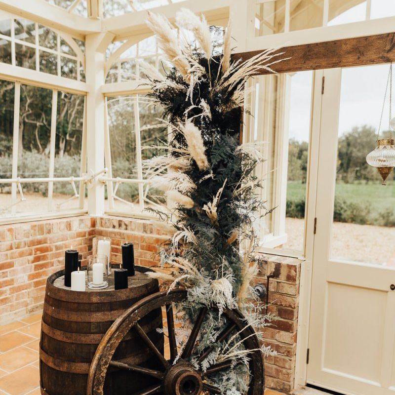 western wedding decor with dried grasses, wooden barrel and waggon wheel