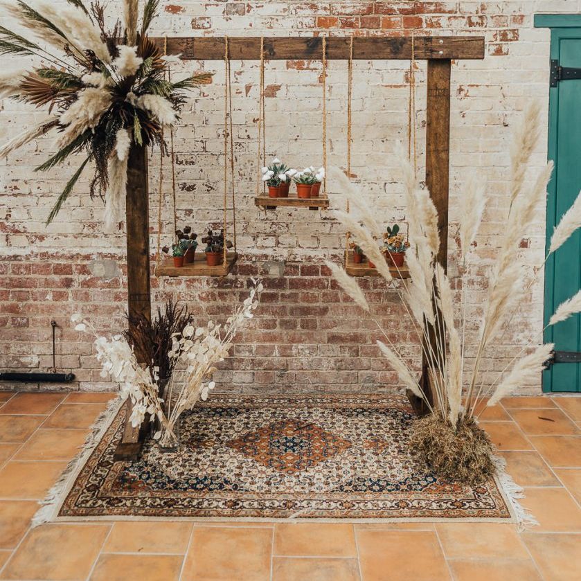 Hanging cake table decorated with dried grasses for western wedding