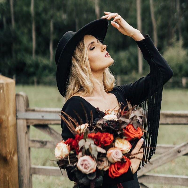 Bride in black wedding dress with fringe sleeves