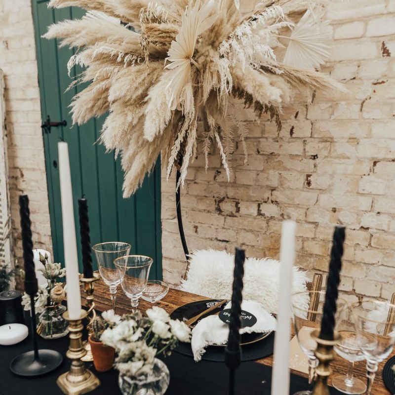 Tablescape with black linen and tableware with gold candlesticks and cutlery for western wedding