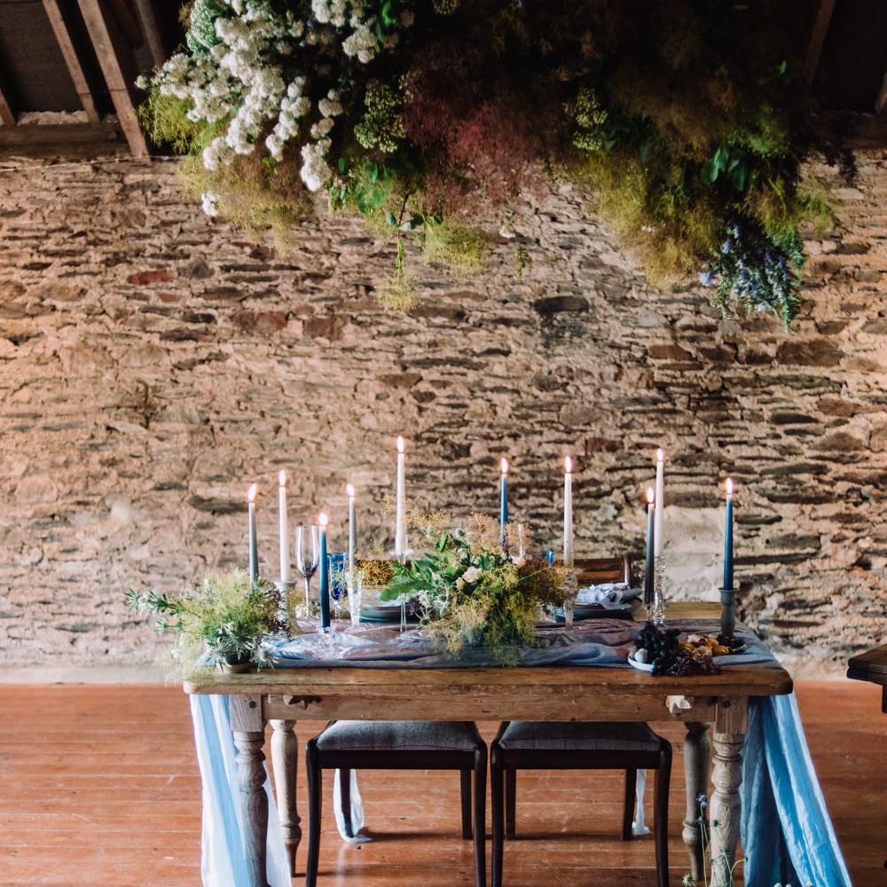 Elegant Tablescape with Floral Installation, Blue Taper Candles &amp; Linens | Wild Coastal Elopement, Bridal Inspiration at New Barton Barns, Devon | Liberty Pearl Photography &amp; Film