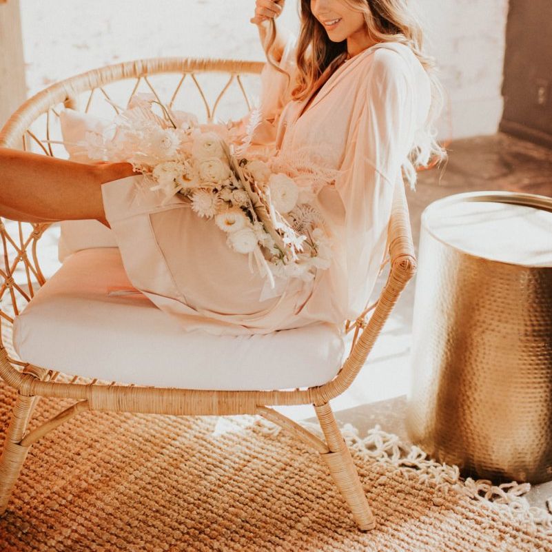 Bride in getting ready robe holding a white boho bouquet