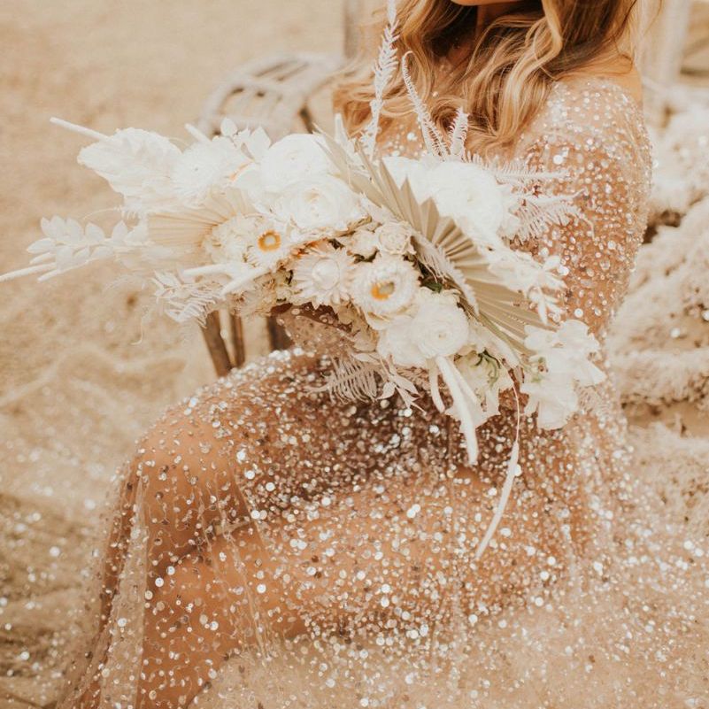 Boho wedding bouquet with white flowers, dried grasses and palm leaves