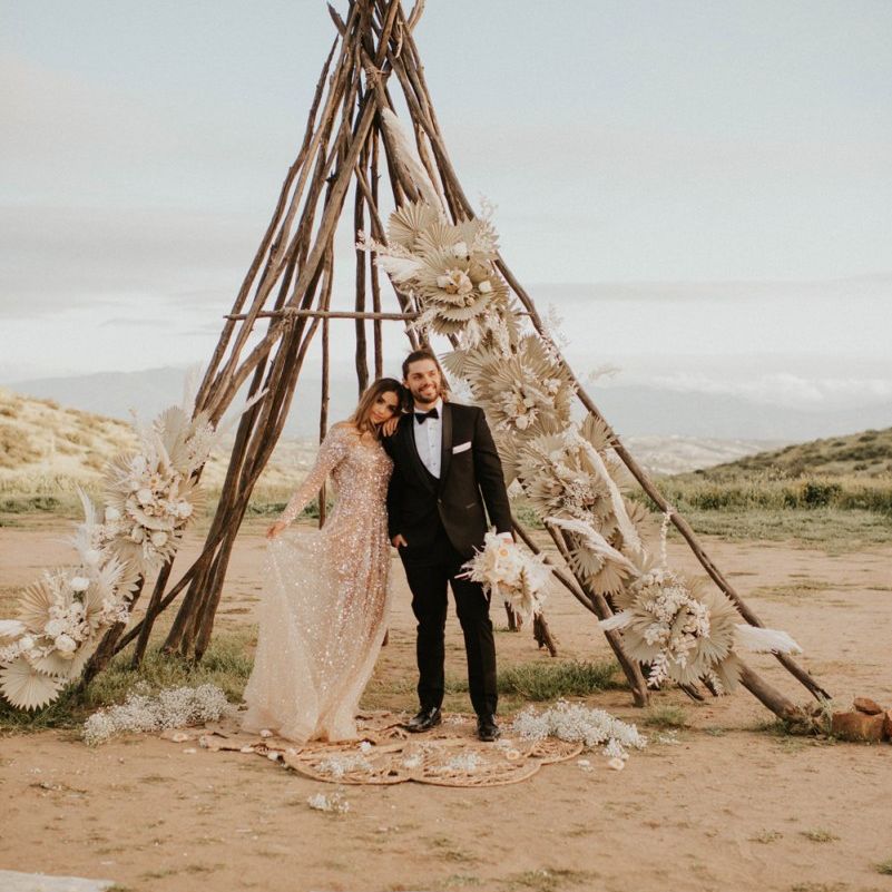 Naked tipi decorated with dried palm leaves and grasses