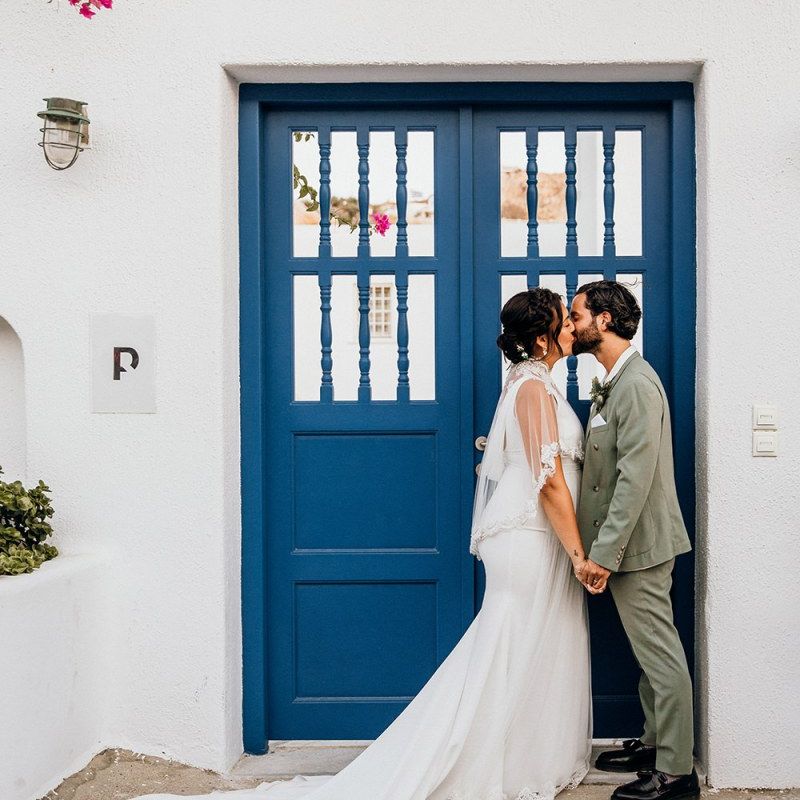 Bride in wedding capelet kisses new husband