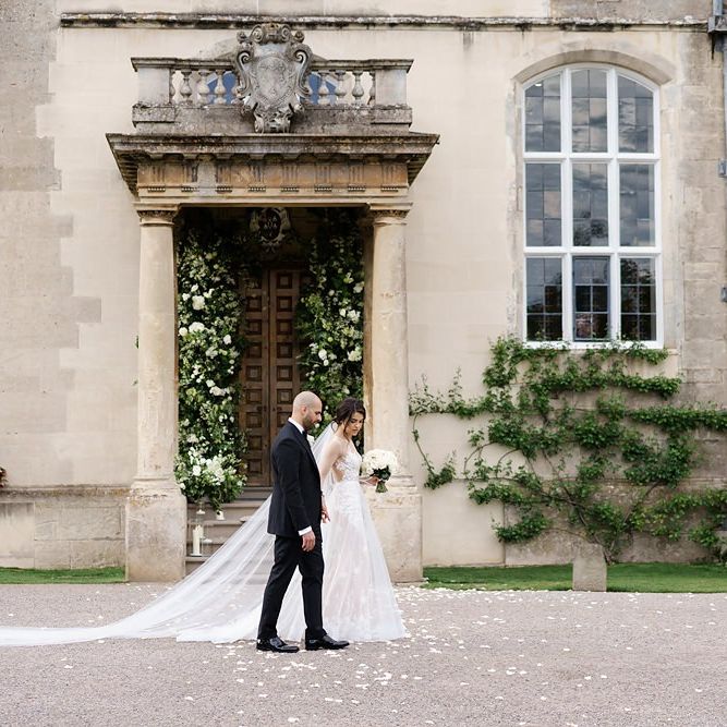 Bride and GRoom in Classic Black Tie Attire Walking In Front Of Elmore Court Wedding Venue