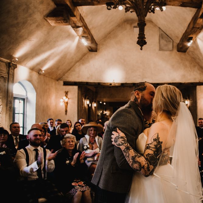 Wedding Ceremony with Bride in Essense of Australia Wedding Dress Kissing the Groom in a Tartan Kilt