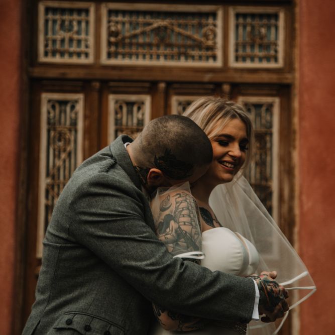 Groom in Highland Wear Embracing His Bride