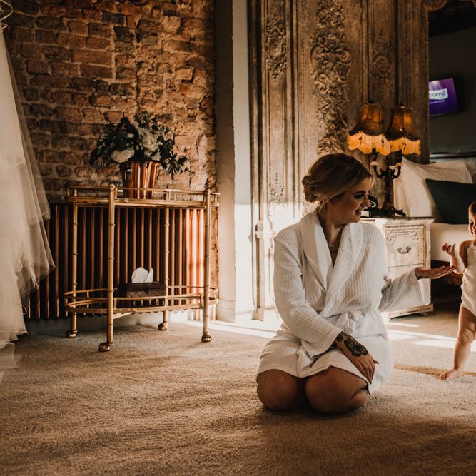 Wedding Morning Bridal Preparations with Bride in Getting Ready Robe Kneeling Down Playing With Her Daughter