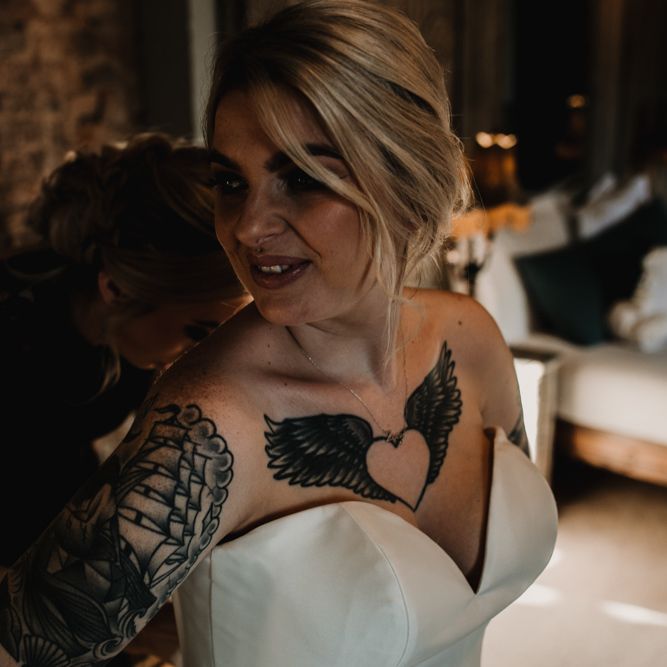 Bride in Sweetheart Neckline Wedding Dress Showing Off Her Heart and Wings  Tattoo