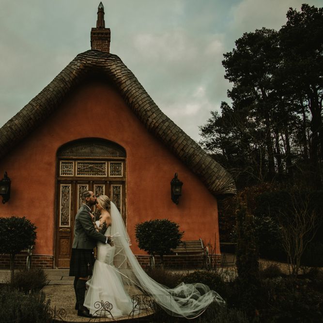 Bride in Fishtail Essense of Australia Wedding Dress and Groom in Tartan Kilt Kissing