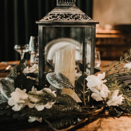 Lantern Centrepiece Surrounded by White and Green Wedding Flowers