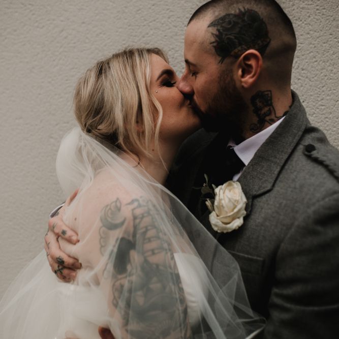 Bride in Essense of Australia Wedding Dress and Groom in Highland Attire Kissing