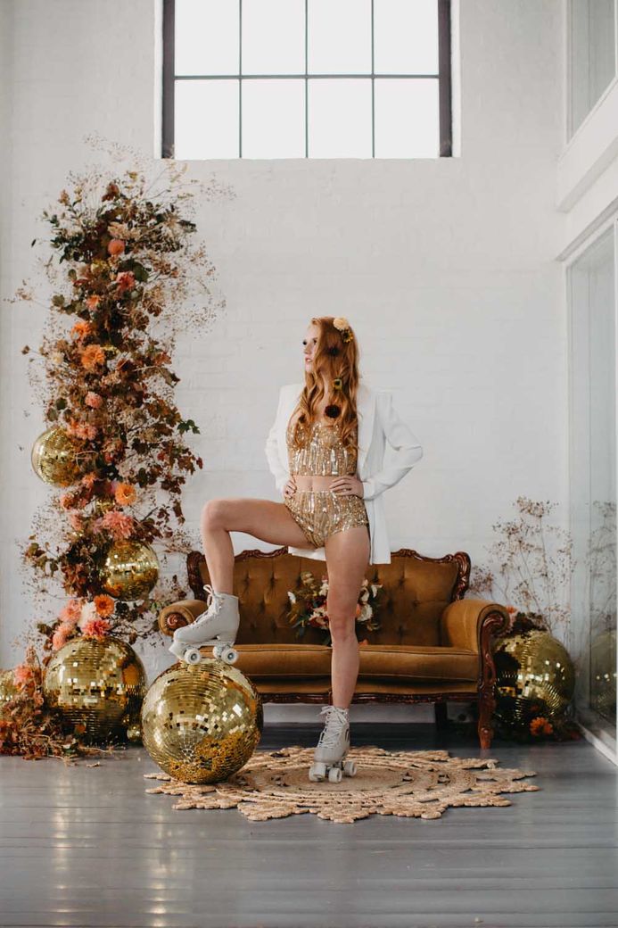 Autumn column wedding flowers and retro 70s wedding decor with gold hotpants and glitter balls