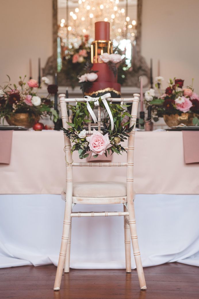 Floral hoop chair back wedding decor with foliage, roses and ribbon 
