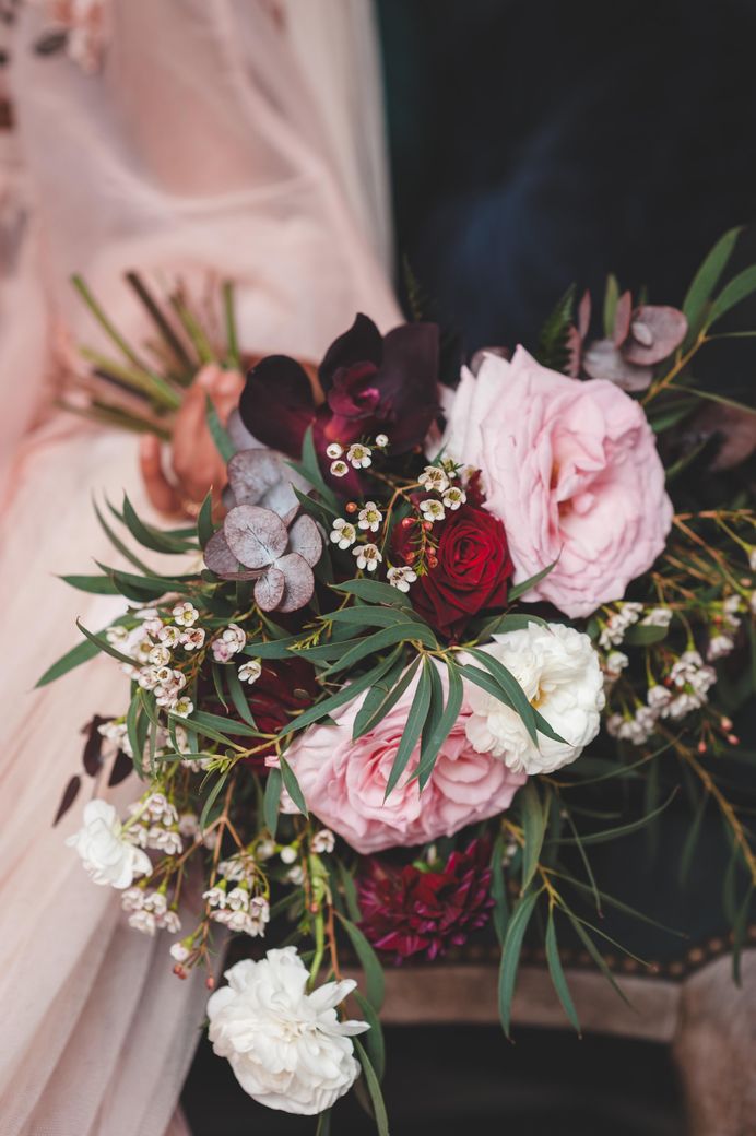 Deep red, pink and white rose wedding bouquet with green foliage 