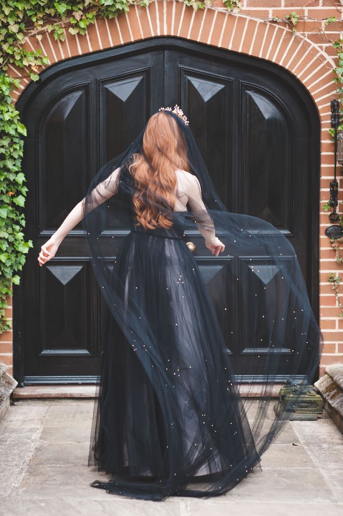 Bride in a one shoulder black tulle wedding dress with dramatic black veil at autism marriage wedding inspiration