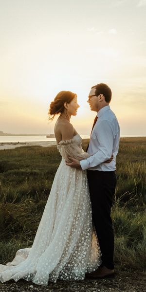 A couple along the Swale estuary at sunset at The Ferry House barn wedding venue by Matt Ebbage.