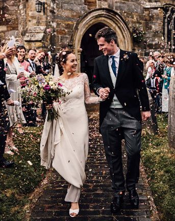 Bride and groom have colourful confetti exit from their church wedding ceremony before going to Wadhurst Castle for their reception.