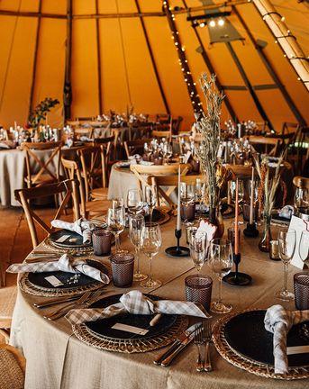 Tipi wedding with neutral wedding table decor and tablescape with warm lighting