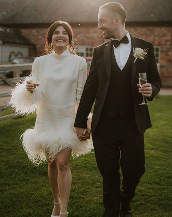Larkspur Lodge wedding with bride wearing a short feather wedding dress with groom in black tuxedo