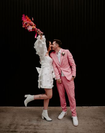 bride in short wedding dress with groom in pink suit at pink retro disco theme wedding