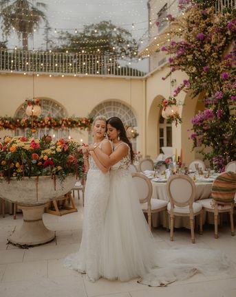 LGBTQIA+ Croatia wedding with two brides in lace wedding dresses and bright wedding flowers