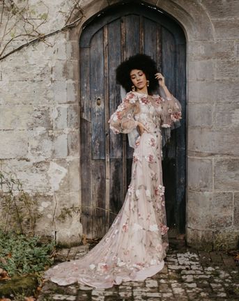 Black bride with afro hair in a 3D flower pink embroidered wedding dress at Chiddingstone Castle