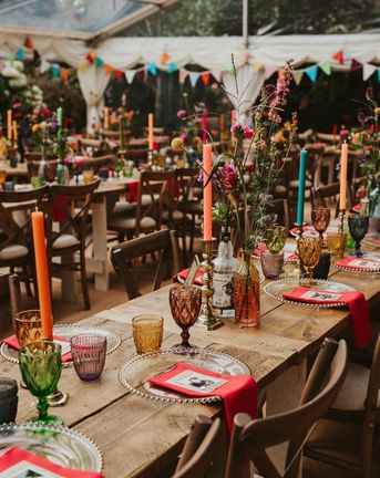 Clear marquee wedding reception in a back garden with colourful flower and table decor 