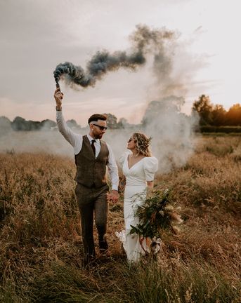 Willow Marsh Farm wedding with the bride and groom waving smoke bombs