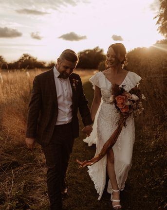 Bride in a bespoke Emma Beaumont Atelier wedding dresss with the groom in a grey suit.