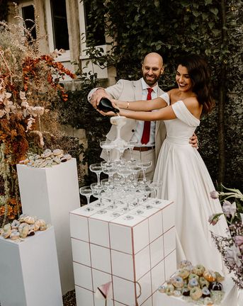 Bride and groom pour their champagne tower for their wedding at Chapel House Estate.