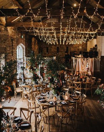 Autumn theme wedding at Askham Hall in cumbria with fairy lights and tree centrepieces 