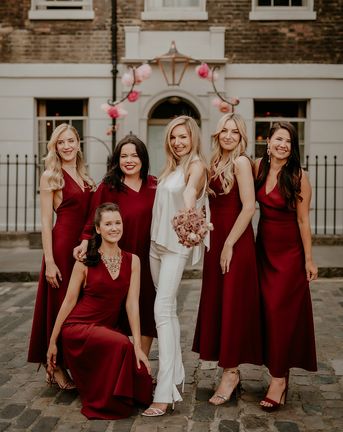 Bride with bridesmaids in dark red bridesmaid dresses for townhouse wedding.
