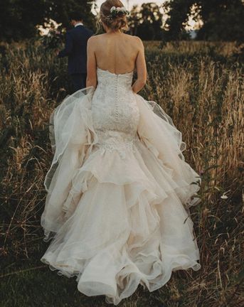 Mermaid wedding dress worn by the bride running through a field.