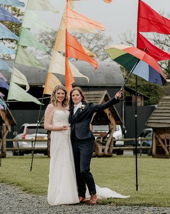 LGBTQIA+ Stanford Farm Pride wedding with rainbow festival flags, fairy lights and foliage weddng decor by The Bearded Man Photography
